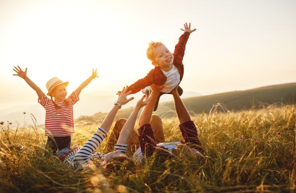 Familie Vater, Mutter, Sohn und Tochter speilen in einer Wiese