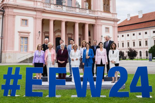 Bundesministerin Edtstadler (vorne, dritte von links) mit zwölf weiteren Personen - sie stehen vor einer Kirche, zu sehen ist auch der Schriftzug "#EFW24"