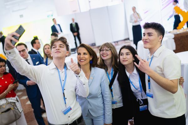 Bundesministerin Karoline Edtstadler umgeben von Jugendlichen bei der Jahrestagung der Europa-Gemeinderätinnen und Europa-Gemeinderäte in der Österreichischen Nationalbibliothek.