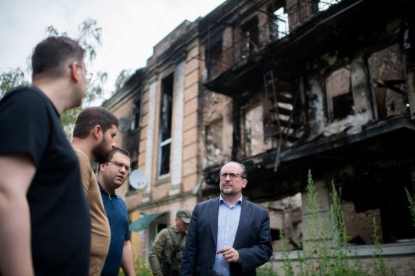 Außenminister Schallenberg (rechts im Bild) spricht mit drei Personen in einer ukrainischen Stadt