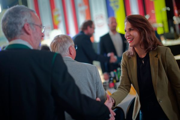 Foto: Bundesministerin Karoline Edtstadler reicht einem Mann beim Europafest am Gemeindetag die Hand.