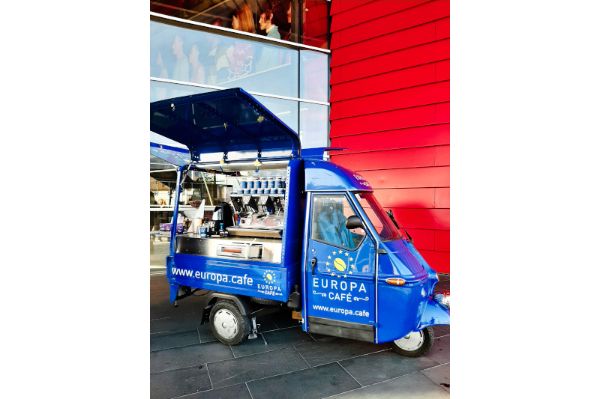 Die Europa.Cafè Ape steht vor einem Gebäude