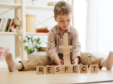 Junge vor Bausteinen mit dem Wort Respect