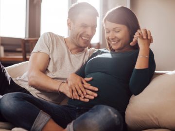 Mann mit schwangerer Frau, berührt Bauch