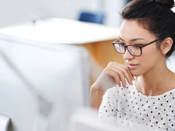 Junge Frau sitzt vor dem PC 