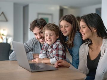 Familie mit zwei Kindern vor Computer 