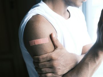 Mensch mit Pflaster am Oberarm 