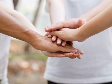 Personen, die ihre Hände übereinander legen